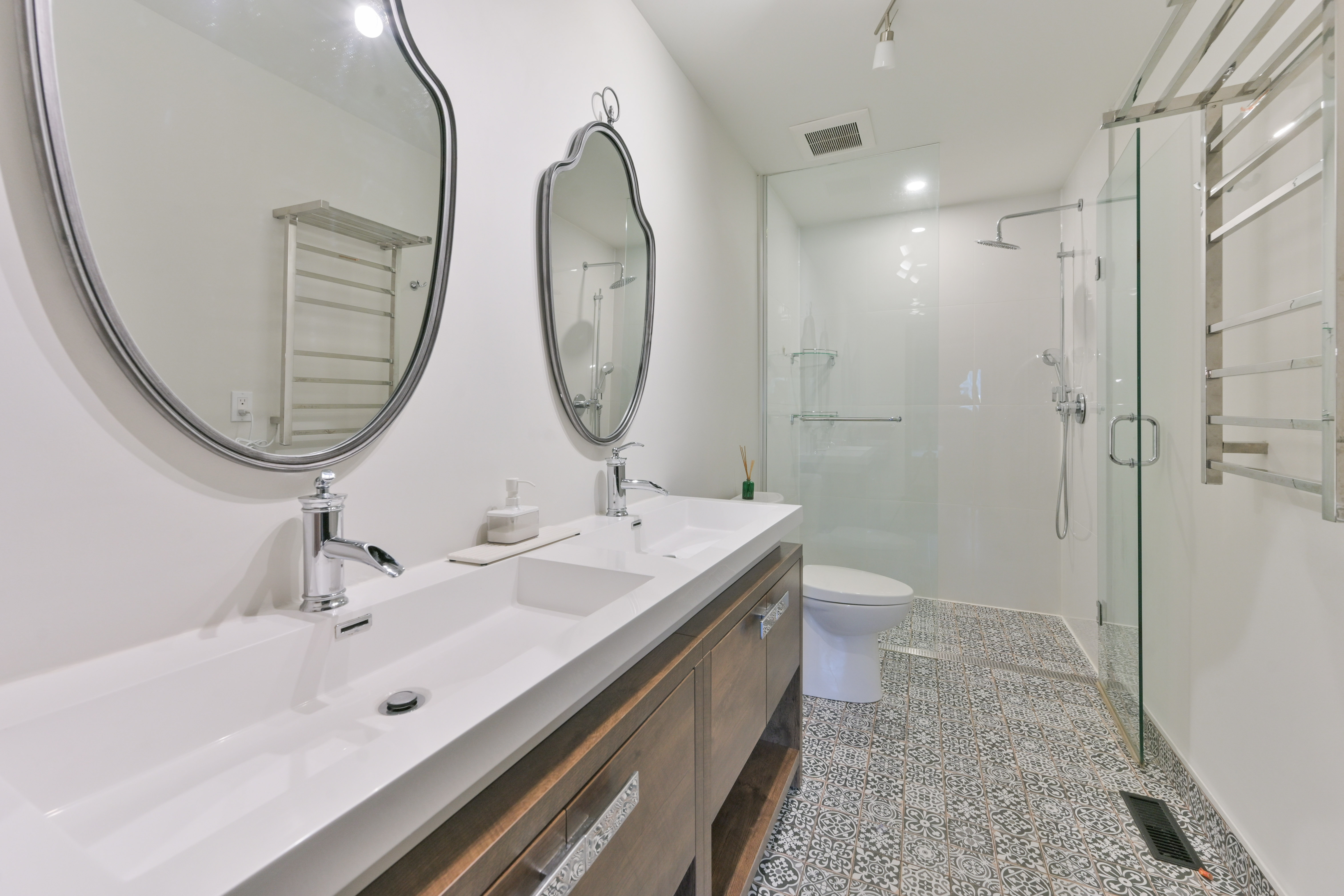 Primary ensuite with double vanity, glass shower, towel warmer