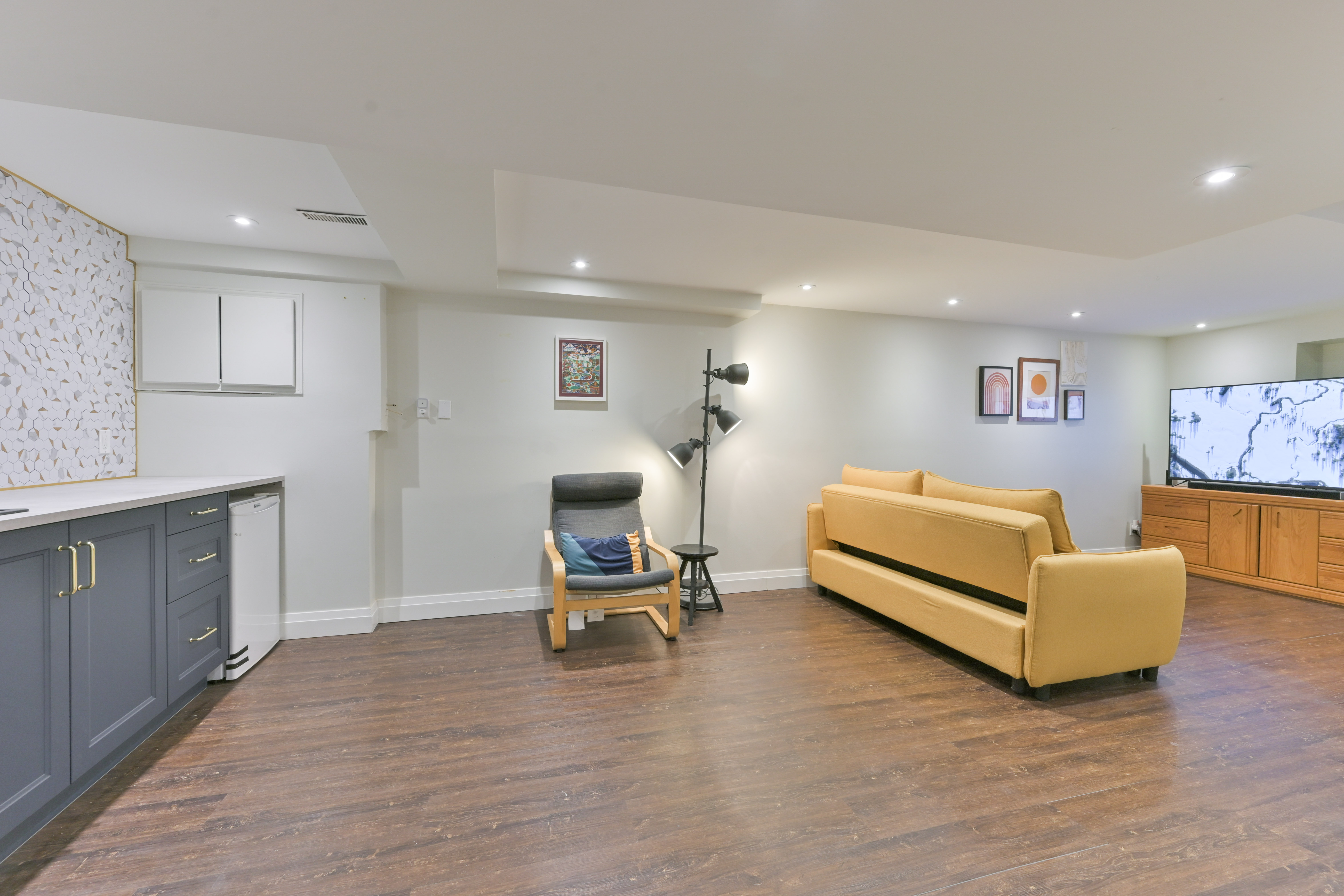 Finished basement with wet bar and yellow sofa